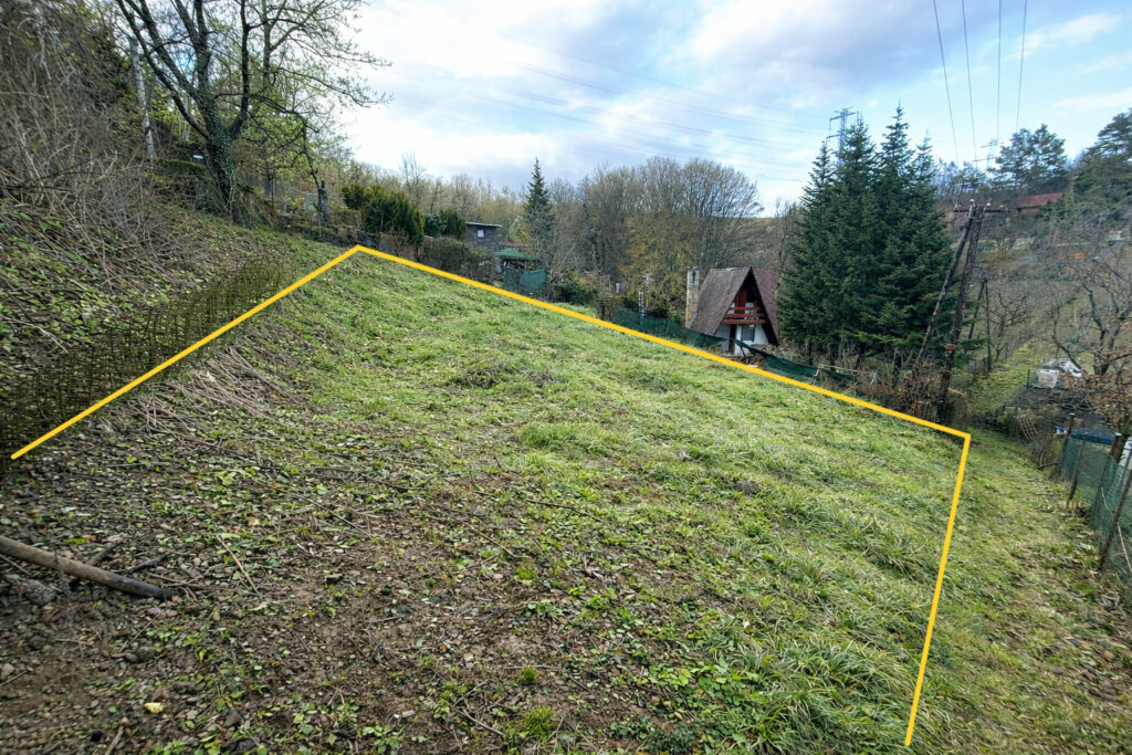 Pohľad na slnečný záhradný pozemok v Kavečanoch s vyznačenou hranicou.